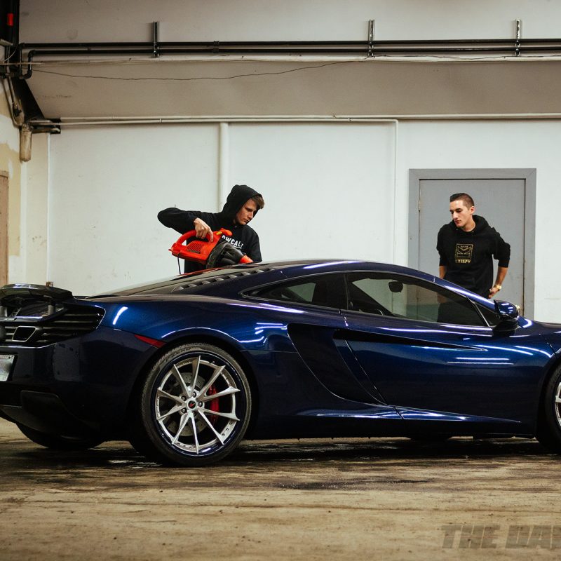 Chris and Anthony drying water droplets off the cleaned McLaren