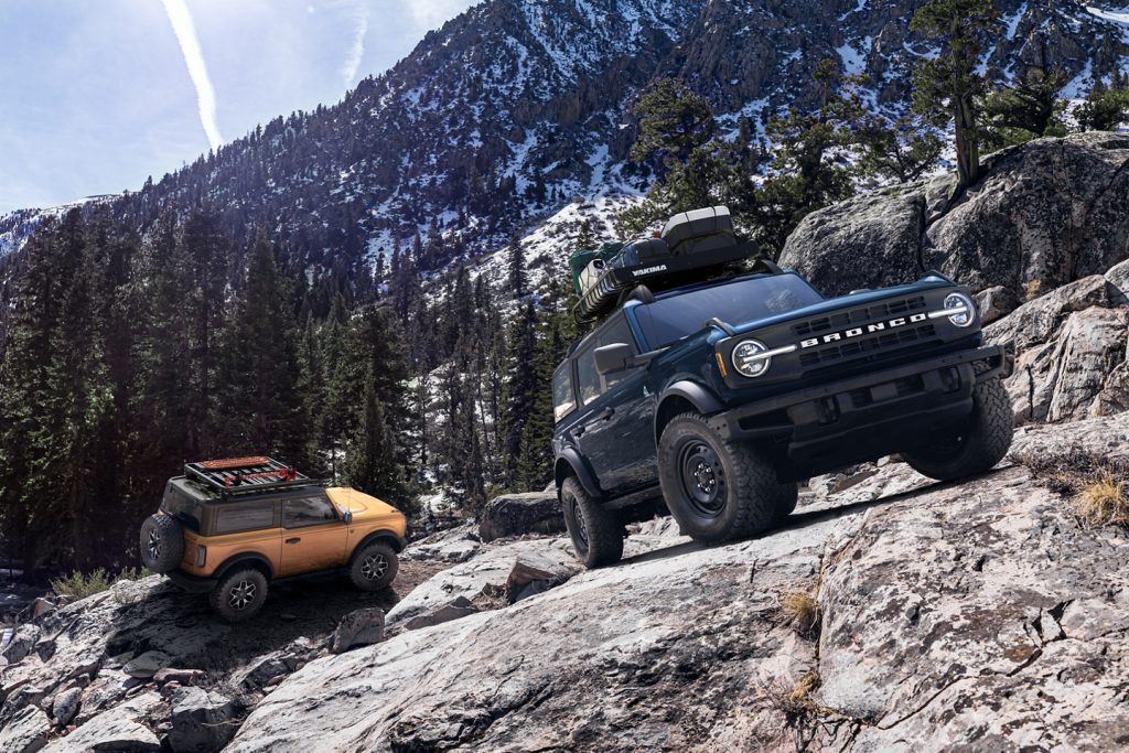 pair of Ford Broncos climbing rocks in the mountiains