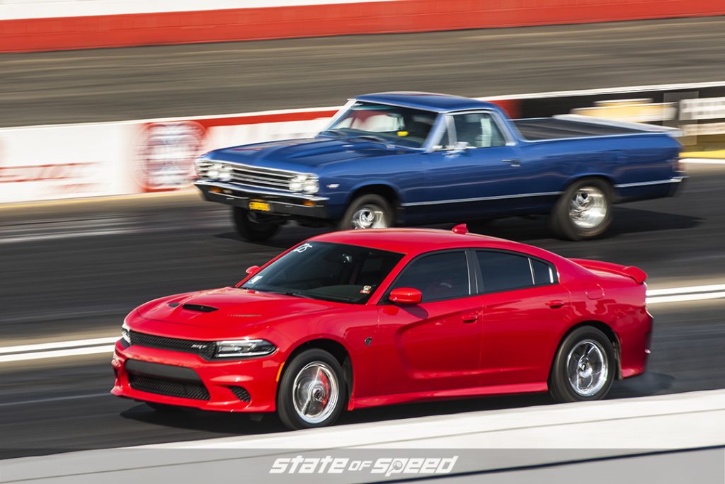 red 2015 dodge charger SRT racing a blue Chevy El Camino on the drag strip