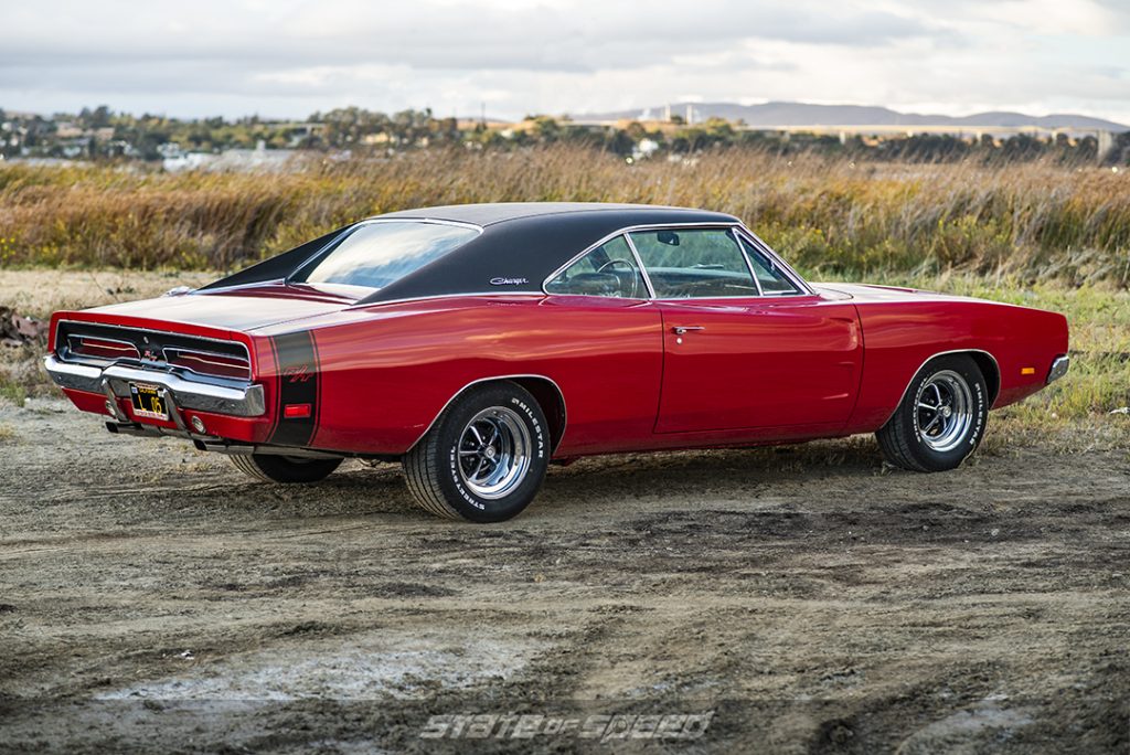 rear of red '69 dodge charger in field
