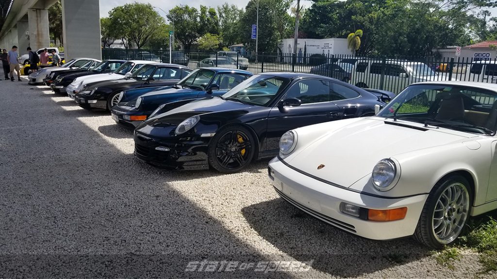 line up of several white, black, and blue porsches outside of Parkhaus1