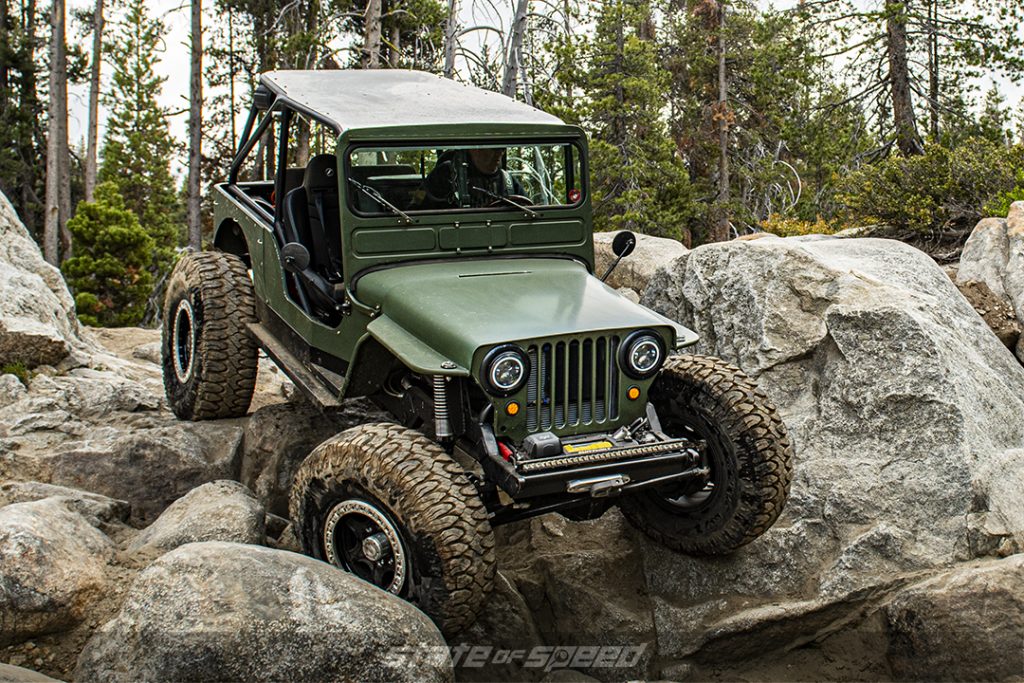 olive green 1946 jeep willys crawling on rocks 
