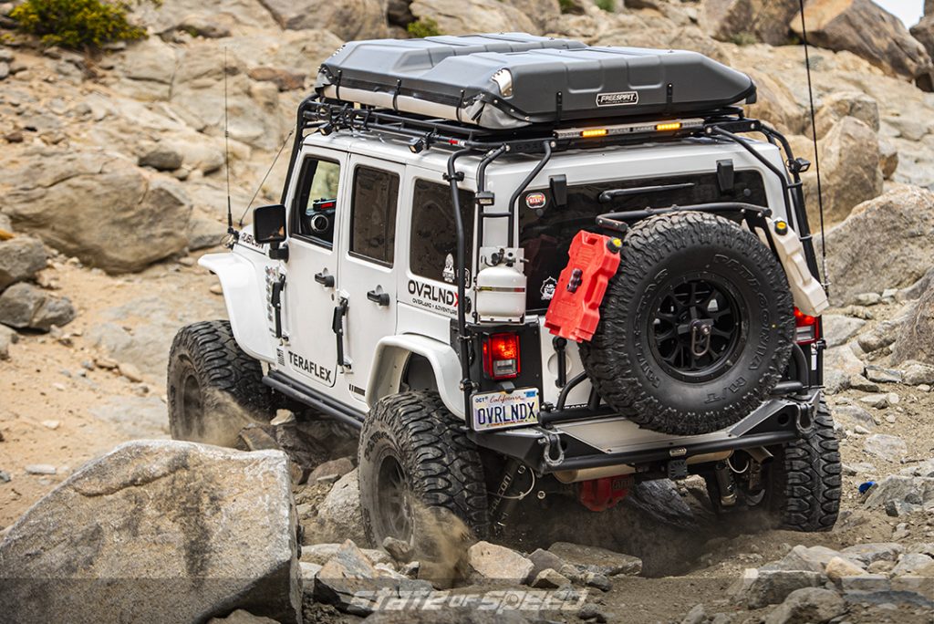 White jeep jk overlander crawling up rocky hill on Patagonia M/T Tires