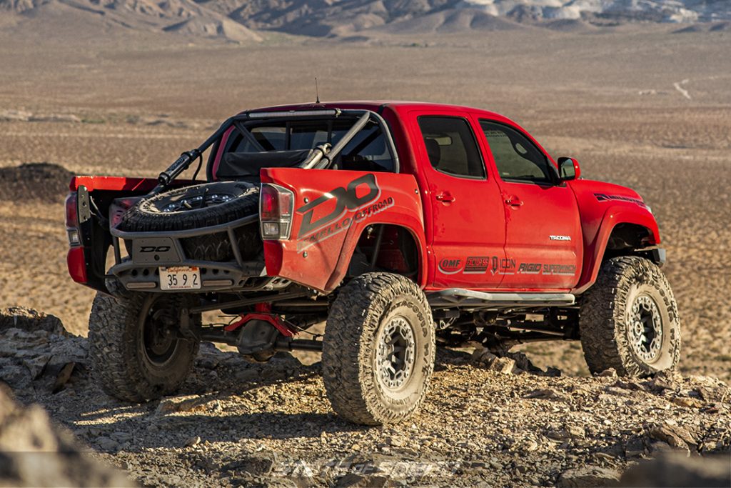 rear of a red toyota tacoma overlooking a desert