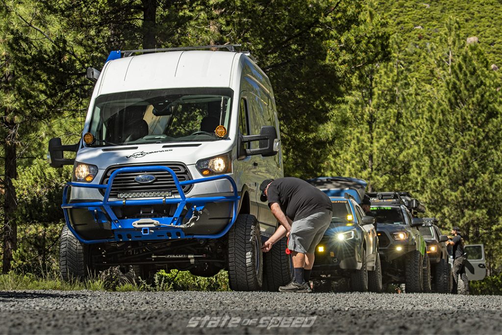 Ford transit van on milestar X/T tires followed by a blue subaru wilderness and a toyota tacoma