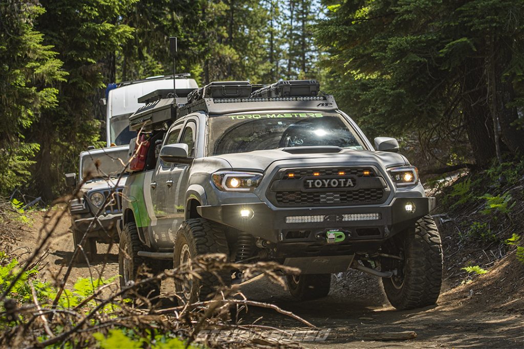 Torq-Masters Gray Toyota Tacoma followed by a jeep in a forest trail