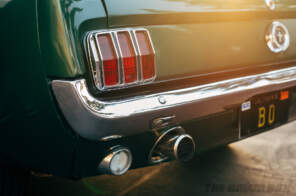 Close-up of the taillights and exhaust tailpipe on the Green 1965 Mustang Fastback 2+2