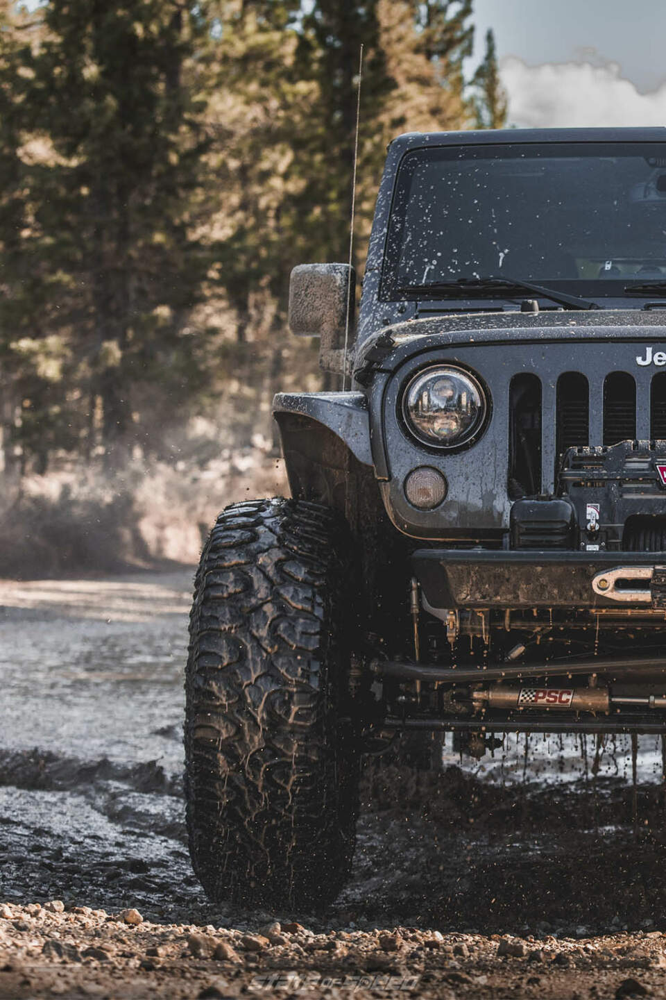 Grey Jeep JK going through mud