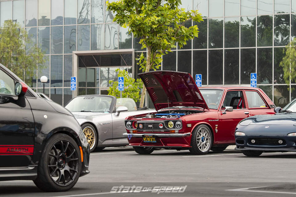 Red Datsun 1300B, dark blue Mazda RX-7,and Fiat 300 Abarth at State of Speed Los Angeles LA